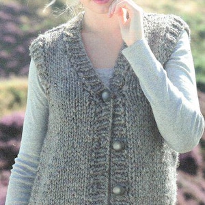 Può includere: Un gilet di maglia grigia con scollo a V e chiusura con bottoni. Il gilet è realizzato con un filato spesso e ha un motivo testurizzato.