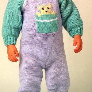 May include: A knitted baby onesie in light purple with a green and white pocket featuring a cartoon bear. The onesie has long sleeves and a crew neck.