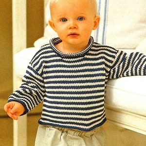 May include: A toddler wearing a striped blue and white jumper with a round neckline. The jumper is knitted and has a casual look.