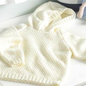 May include: Cream-colored knitted baby hoodie with a textured pattern. The hoodie features a hood, long sleeves, and ribbed cuffs and hem. The soft, warm sweater is designed for a baby or toddler.