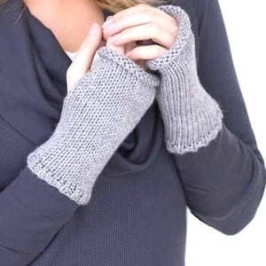 May include: A pair of gray fingerless knit gloves. The gloves are made of a soft, warm material and have a simple, classic design.