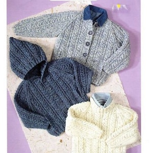 May include: Three knitted sweaters and jackets in shades of blue and cream are displayed. The top jacket is gray with a denim collar and button closure. A hooded blue jacket and a cream-colored sweater are also shown. The text "Aran Knitting" and "Sweater and jackets" are visible.
