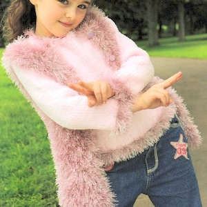 May include: A young girl wearing a pink fluffy sweater with a white sweater underneath and blue jeans with a star patch.