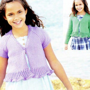 May include: A lilac knitted cardigan with short sleeves and a scalloped hem. The cardigan features a V-neck and a single button fastening. A second image shows a green cardigan.
