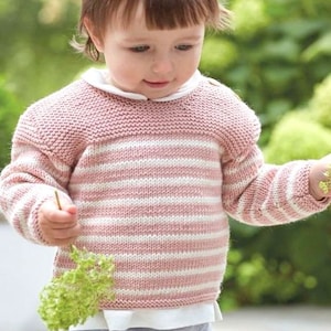 Puede incluir: Un suéter de punto de rayas rosa y blanco con cuello redondo. El suéter está hecho con un hilo suave y texturizado.
