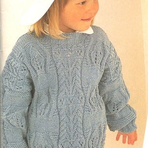 Pode incluir: Um suéter de malha azul claro com um padrão de trança. O suéter tem um decote redondo e mangas compridas.