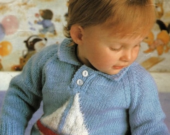 May include: A blue knitted sweater with a white sailboat design and red trim. The sweater has a collared neckline and two white buttons.