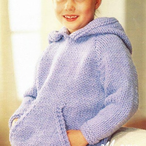 Pode incluir: Um moletom lilás de malha grossa com um bolso canguru. O capuz é preso e as mangas são compridas. A palavra "CHUNKY" está em uma caixa branca no canto superior esquerdo. A palavra "Magnum" está em fonte cursiva no canto inferior direito.