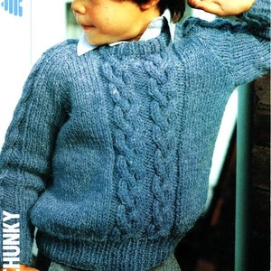 Könnte beinhalten: Ein blauer Strickpullover mit einem Zopfmuster. Der Pullover hat einen runden Ausschnitt und lange Ärmel.