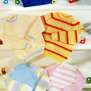 Peut inclure: Quatre pulls tricotés dans différentes couleurs et motifs. Les pulls sont bleus, jaunes à rayures rouges, crème à rayures bleues et roses à rayures blanches.