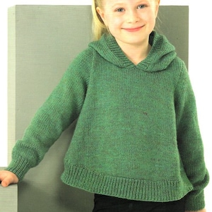 Könnte beinhalten: Ein grüner Kapuzenpullover mit gerippten Säumen und Bündchen. Der Pullover ist gestrickt und hat eine lockere Passform.