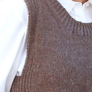 Könnte beinhalten: Eine braune, gestrickte, ärmellose Strickweste mit einem dezenten Ombre-Effekt.