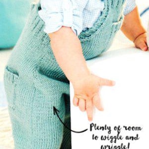 May include: A baby wearing a light blue knitted overall with a white and blue checkered shirt. The overall has pockets and rolled cuffs. The text on the side says "Plenty of room to wiggle and wriggle!"