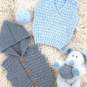 May include: Two knitted baby vests, one blue and one gray, with a blue yarn ball and a gray stuffed animal. The vests are both sleeveless and have a button closure. The blue vest has a V-neck and the gray vest has a hood.