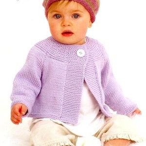 May include: A baby wearing a lavender knitted cardigan with a single white button. The cardigan has a round neckline and long sleeves. The baby is also wearing a pink and white striped hat.