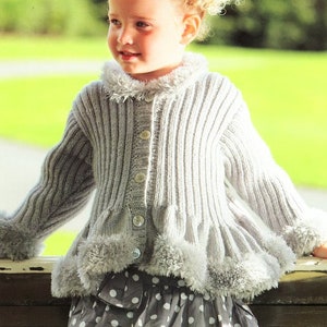 May include: A light grey knitted cardigan with a fluffy white trim around the collar, cuffs, and hem. The cardigan has a button closure and a ribbed texture.