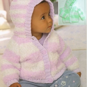 Peut inclure: Un bébé portant un cardigan à capuche tricoté. Le cardigan est rayé blanc et violet clair avec une capuche assortie. Le cardigan a une fermeture à boutons. Le bébé porte un jean bleu.