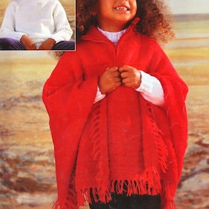 May include: A red knitted poncho with fringe trim. The poncho has a high collar and a zipper closure. The model is wearing black pants.