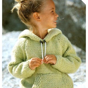 May include: A pale green knitted hoodie with a kangaroo pocket and a drawstring. The hoodie has a hood and is worn by a young person. The text "QUICK & EASY" is in the upper right corner.