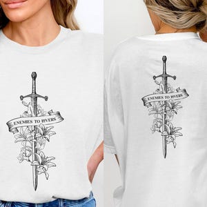 a woman wearing a t - shirt with a sword and flowers on it