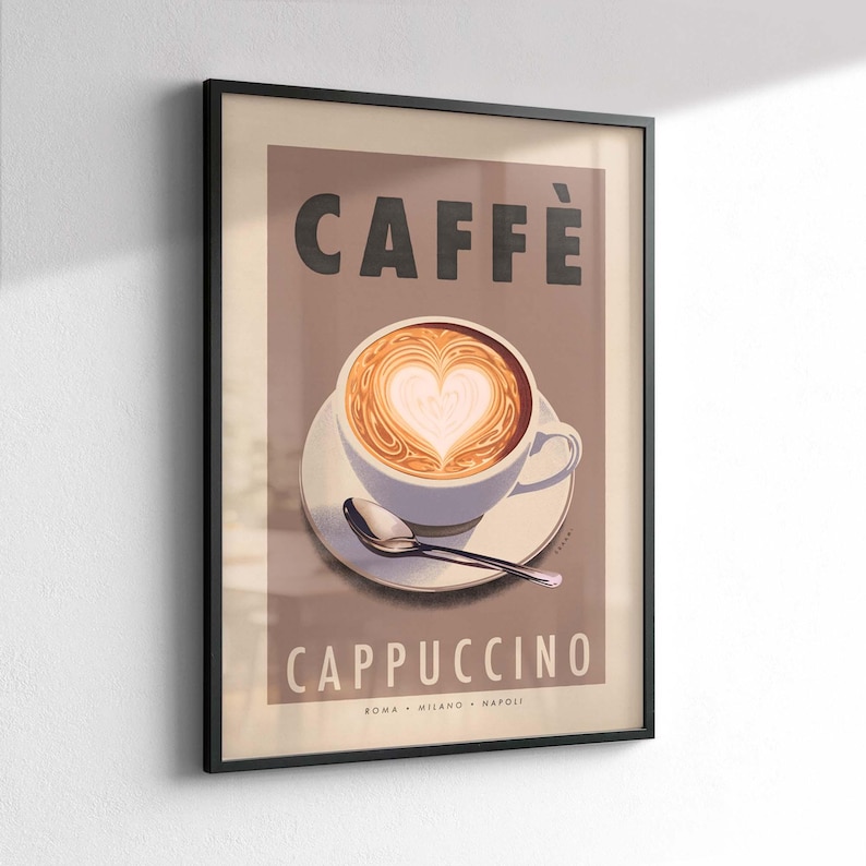 Op de afbeelding: Ingelijste kunstprint met een cappuccino met hartvormige latte art. Het woord "CAFF&Egrave;" staat bovenaan, met "CAPPUCCINO" eronder. De print bevat de steden Rome, Milaan en Napels. Het kunstwerk zit in een zwart frame.