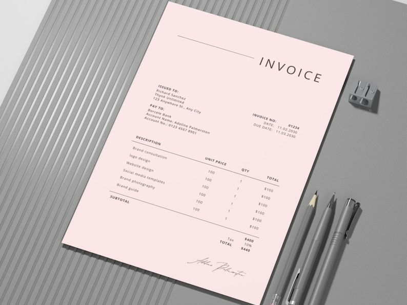 May include: A pink invoice with the word "INVOICE" at the top. The invoice includes details such as invoice number, date, and a list of services with unit prices and totals. Two pens, a pencil, and a stapler are on the gray surface.