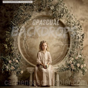 Puede incluir: Una niña con un vestido rosa claro está sentada en un banco frente a un telón de fondo. El telón de fondo presenta un gran diseño circular con arreglos florales y el texto "CPASCUAL BACKDROPS". La escena tiene una estética vintage y romántica.