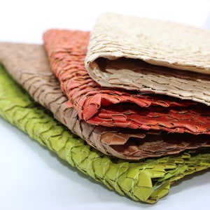 May include: Stack of four woven placemats in green, brown, orange, and beige.