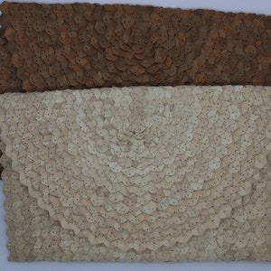 May include: Two leather clutches with a unique geometric pattern. The top clutch is brown and the bottom clutch is white.