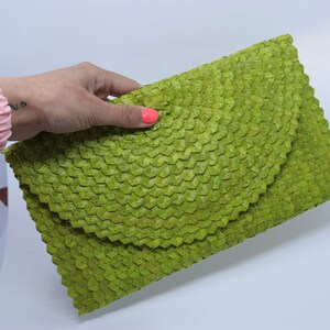 May include: A lime green woven clutch bag with a unique, textured design.