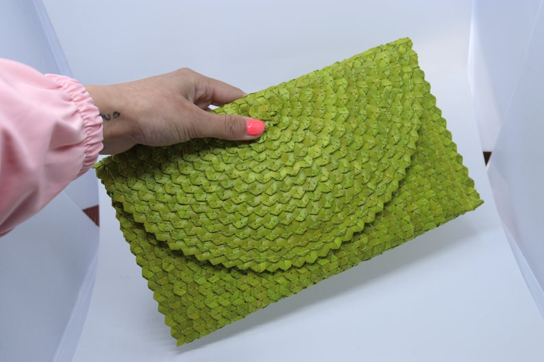 May include: A lime green woven clutch bag with a unique, textured design.