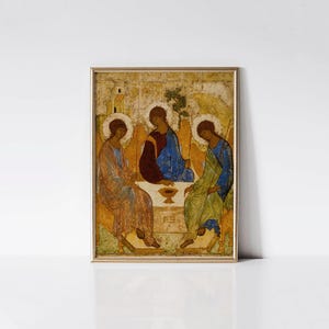 May include: Framed religious icon featuring three figures in robes, seated around a table with a chalice. The artwork has a gold frame and a muted color palette of blues, reds, and golds. The figures have halos.