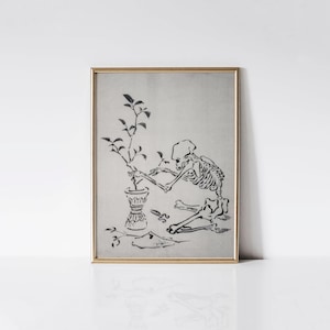 May include: A framed print featuring a black and white illustration of a skeleton tending to a potted plant. The skeleton is seated, with scissors nearby. The artwork has a vintage, gothic aesthetic.