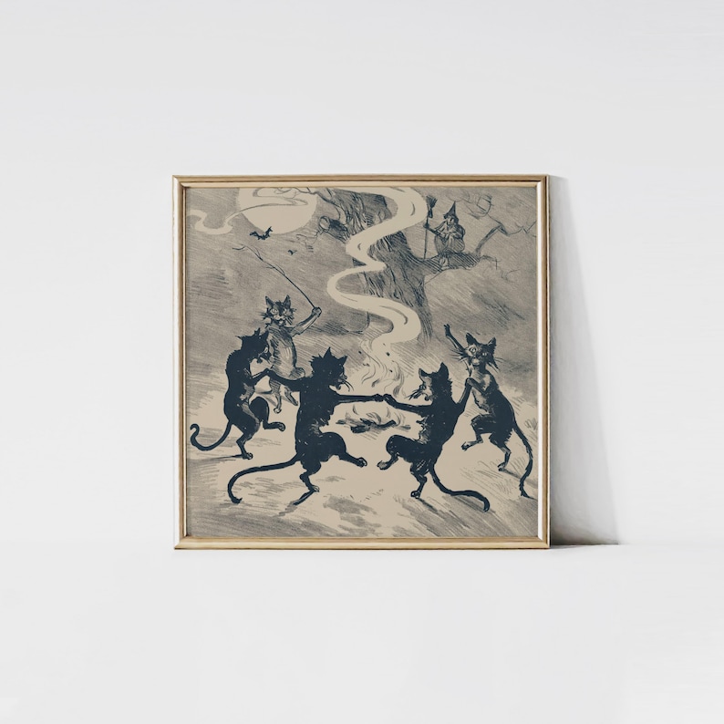 May include: A framed print featuring a vintage illustration of black cats dancing around a fire under a full moon. A witch is perched in a tree, and a bat flies in the sky. The artwork has a sepia tone and is framed in a gold-colored frame.