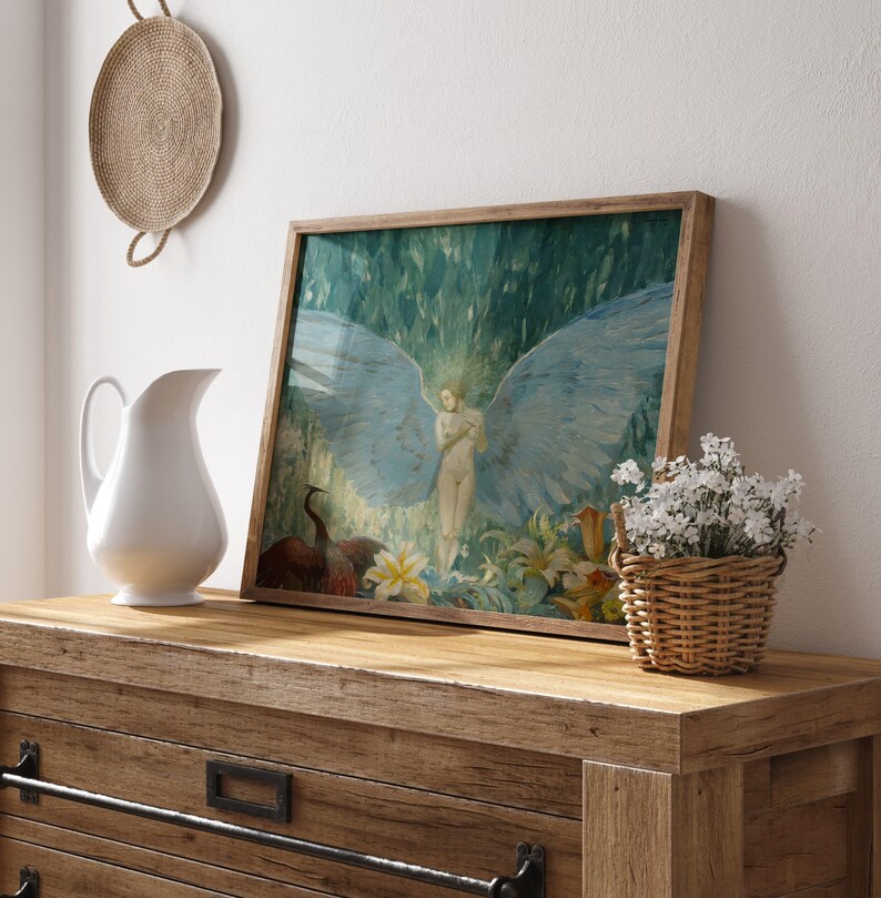 May include: A framed artwork featuring a nude figure with large blue wings, set against a backdrop of lush greenery. The artwork is displayed on a wooden dresser, alongside a white pitcher and a small basket of white flowers.