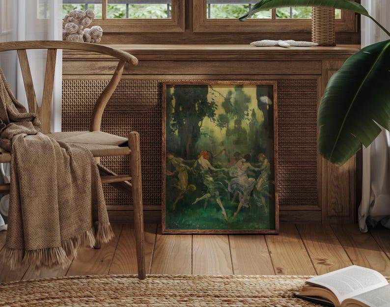 May include: A framed artwork depicting a group of figures dancing in a forest setting. The painting features a palette of greens, browns, and hints of red, with a wooden frame. The artwork is displayed near a wooden chair with a tan throw and a woven rug.