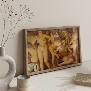 May include: A framed print of a classical painting depicting nude figures in a warm color palette. The artwork is displayed on a white surface, with a decorative vase and candle in the foreground.