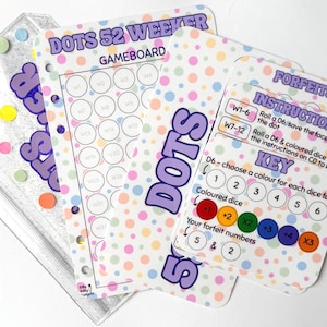 May include: A Dots 52 Weeker game board and instruction card set featuring a white background with colourful pastel polka dots. The game board includes a grid of numbered circles, while the instruction card details rules, forfeits, and a colour key.