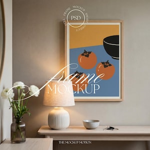 May include: A framed art print featuring a minimalist design with orange persimmons, a black bowl, and geometric shapes in blue and yellow. The artwork is displayed above a table with a lamp, vase of flowers, and a small bowl.