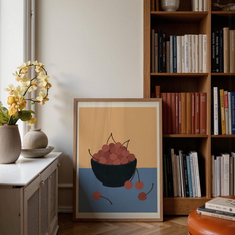 Portrait wooden frame mockups leaning against an oak bookcase in a cozy Scandinavian-style reading nook — soft natural window light, hardwood floor, decorative vases and orchids on a console; styled home decor and print mockups for listings.