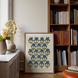 Portrait wooden frame mockups leaning against an oak bookcase in a cozy Scandinavian-style reading nook — soft natural window light, hardwood floor, decorative vases and orchids on a console; styled home decor and print mockups for listings.
