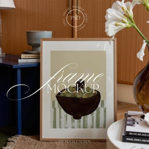 以下が含まれることがあります： 緑色の物体が入った濃い茶色のボウルが特徴の額入りアートプリント。背景は薄緑と白のストライプ。フレームは薄茶色です。「Frame Mockup」の文字が表示されています。