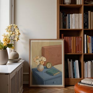 Portrait wooden frame mockups leaning against an oak bookcase in a cozy Scandinavian-style reading nook — soft natural window light, hardwood floor, decorative vases and orchids on a console; styled home decor and print mockups for listings.