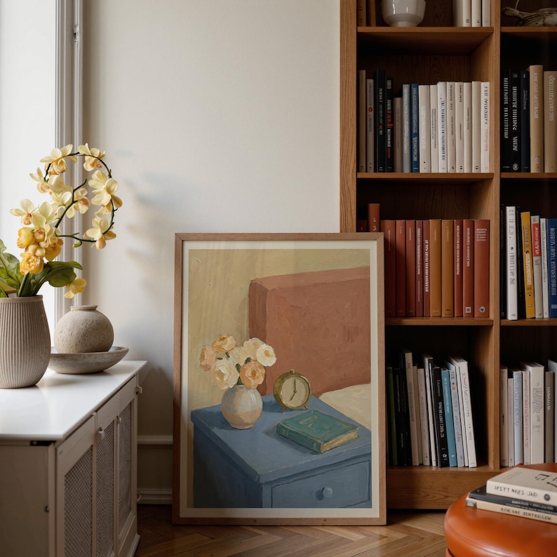 Portrait wooden frame mockups leaning against an oak bookcase in a cozy Scandinavian-style reading nook — soft natural window light, hardwood floor, decorative vases and orchids on a console; styled home decor and print mockups for listings.
