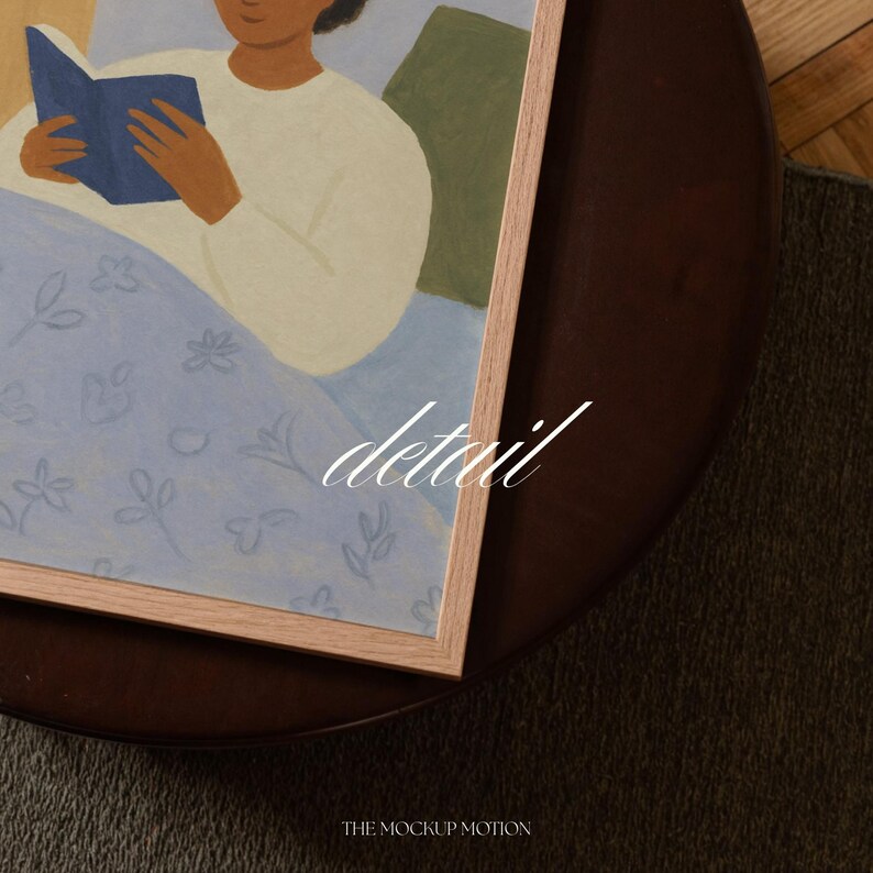 Top-down angled portrait frame mockup: light oak wood frame styled on a round dark brown leather ottoman over a textured neutral rug and parquet hardwood floor, cozy Scandinavian/minimal home-decor staging with natural light — ideal mockup for wall art prints, gallery wall, printable poster listings.