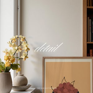 Portrait wooden frame mockups leaning against an oak bookcase in a cozy Scandinavian-style reading nook — soft natural window light, hardwood floor, decorative vases and orchids on a console; styled home decor and print mockups for listings.