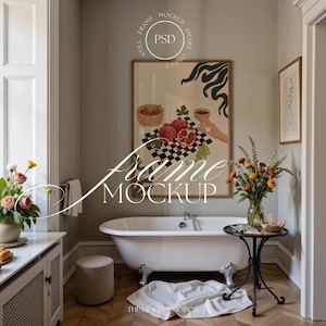 May include: Bathroom interior with a claw-foot bathtub, a framed artwork with a fruit still life, and a small side table with a vase of flowers. The room has a neutral color palette with a wooden floor and a small stool.