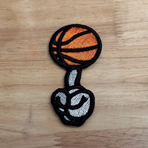 May include: Embroidered iron-on patch of a middle finger giving the bird with a basketball on top.