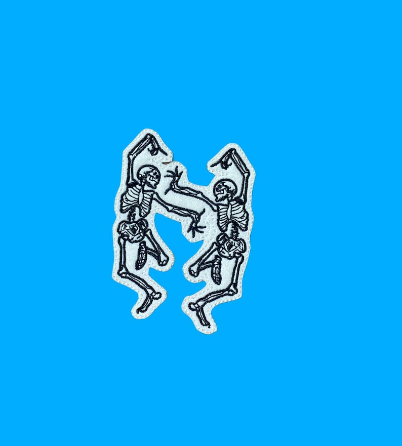 May include: Two white embroidered skeletons dancing against a bright blue background.