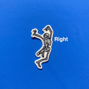 May include: White embroidered patch of a skeleton with arms raised, on a blue background. The word "Right" is written in black text below the skeleton.
